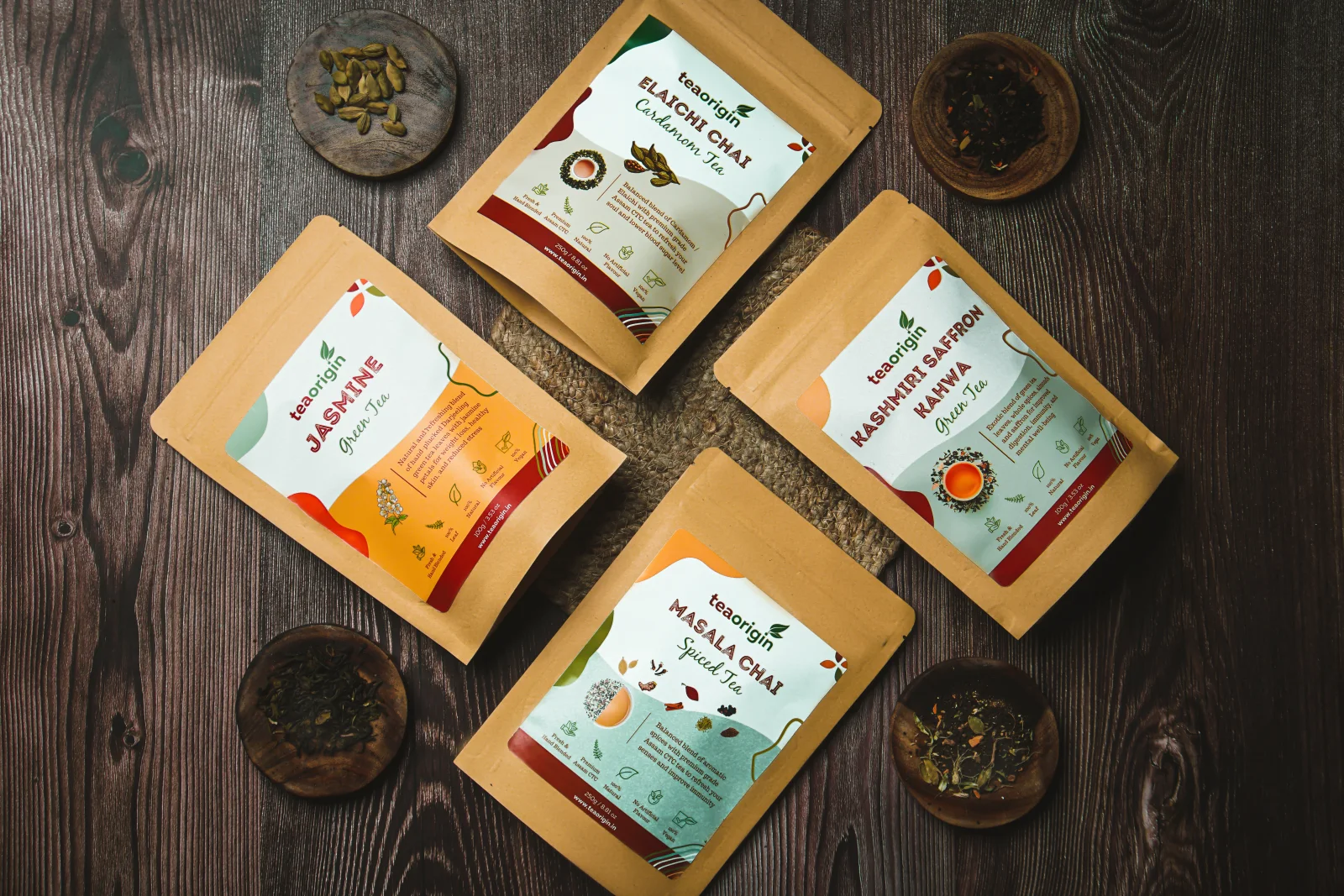 Tea Origin tea packs arranged on a dark wooden table